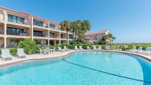 A swimming pool with lounge chairs, a building with balconies, and palm trees. - NEW LISTING!Stunning Sea Place Renovated -Oceanview 1st floor 2bd/bath (St. Augustine)