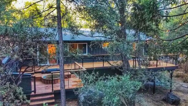 A modern house with a deck, surrounded by trees. - All New, 3 Bdrms, HOT TUB, near town and trails (Idyllwild-Pine Cove)