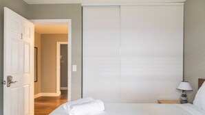 Una camera da letto con un letto, un comodino, una lampada e un armadio.
