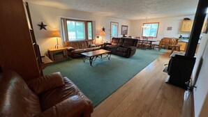 A spacious living room with a large leather couch, a coffee table, and a fireplace. - Golf Course, Close to YNP, Groceries, Restaurants (Island Park)
