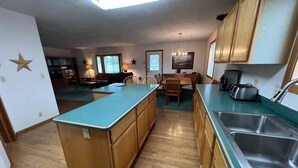 A kitchen with wooden cabinets, a central island, and a sink. - Golf Course, Close to YNP, Groceries, Restaurants (Island Park)