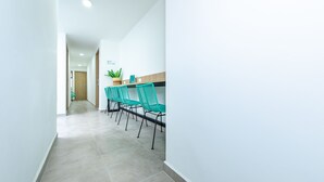 A hallway with teal chairs and a potted plant. - Hotel Medallo City (Medellín)