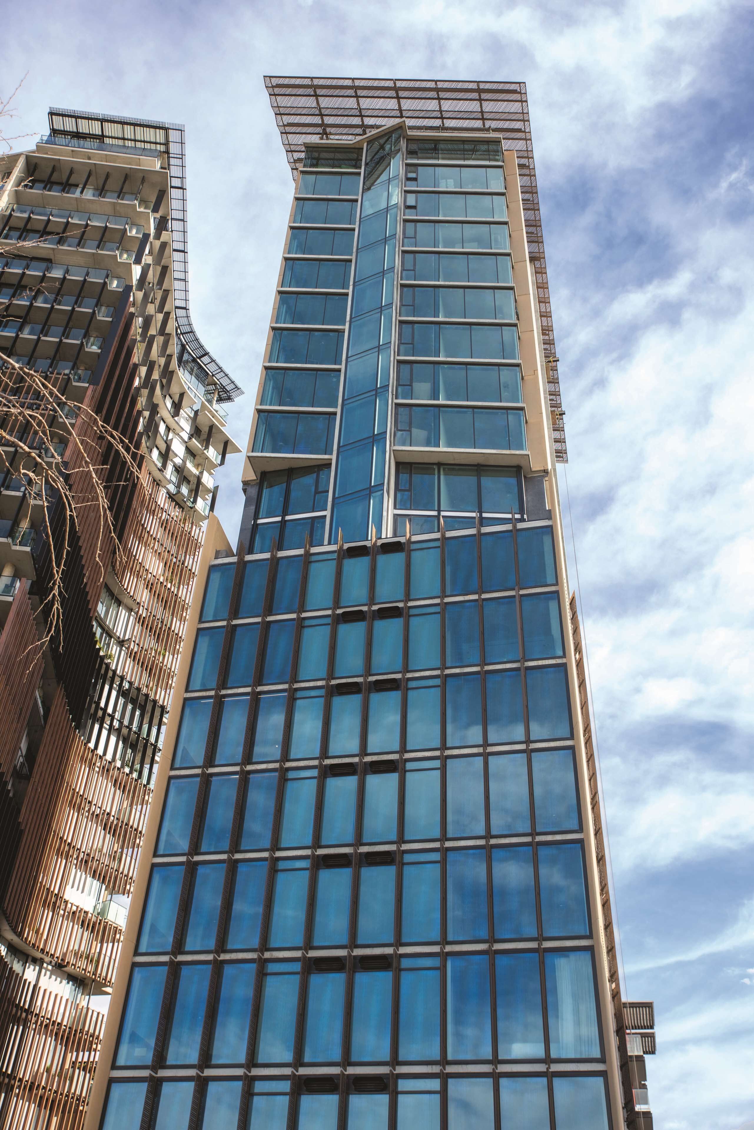 A modern high-rise building with a glass facade and a unique angular design.