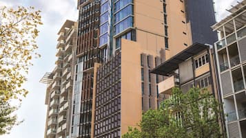 A modern high-rise building with multiple floors, large windows, and a mix of glass and concrete facades.