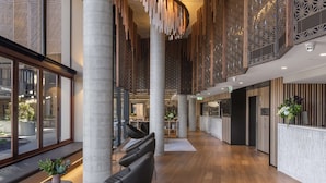 A spacious lobby with high ceilings, large windows, and modern seating areas. - Vibe Hotel Adelaide (Adelaide)