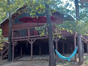 Relax in a serene wooded setting with a balcony and covered porch, perfect for unwinding in a hammock.