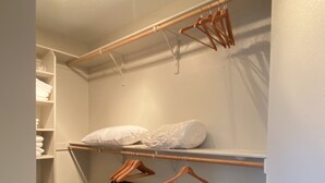 A walk-in closet with shelves, a hanging rack, a bench, and a laundry basket. - Prime Northeast Heights Location - 3 Bedroom - 2.3 mi to Balloon Fiesta Park! (Albuquerque)