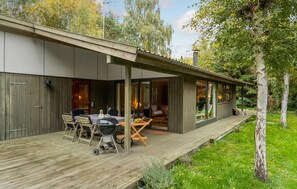 A modern house with a covered patio, a dining area, and a view of the surrounding trees. - 3 bedroom cozy home in Nykøbing Sj (Nykøbing Sj)