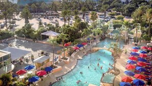 A resort with a central swimming pool, sun loungers, and umbrellas. - Pointe West Family Beach + 2 Resort Pools (Galveston)