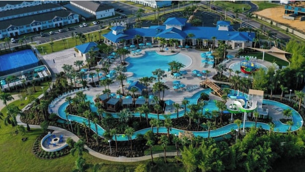 Ett semesterhotell med en stor pool i mitten, flera mindre pooler och en vattenrutschkana.