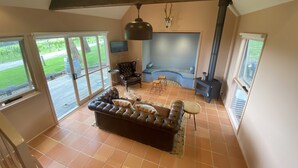 Un salon spacieux avec un grand canapé en cuir, une cheminée et un manteau de cheminée en pierre.