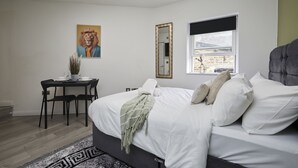 A bedroom with a bed, a desk, a chair, a mirror, and a window. - Hayy Vibrant Studios Queensgate (Huddersfield)