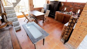 Een landelijke keuken met een bakstenen muur, een houten tafel en een gootsteen.