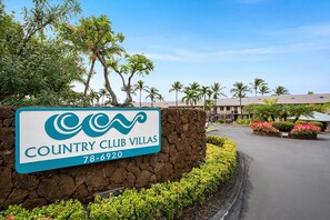 Un panneau indiquant l’emplacement de Country Club Villas, avec un numéro de téléphone à contacter.