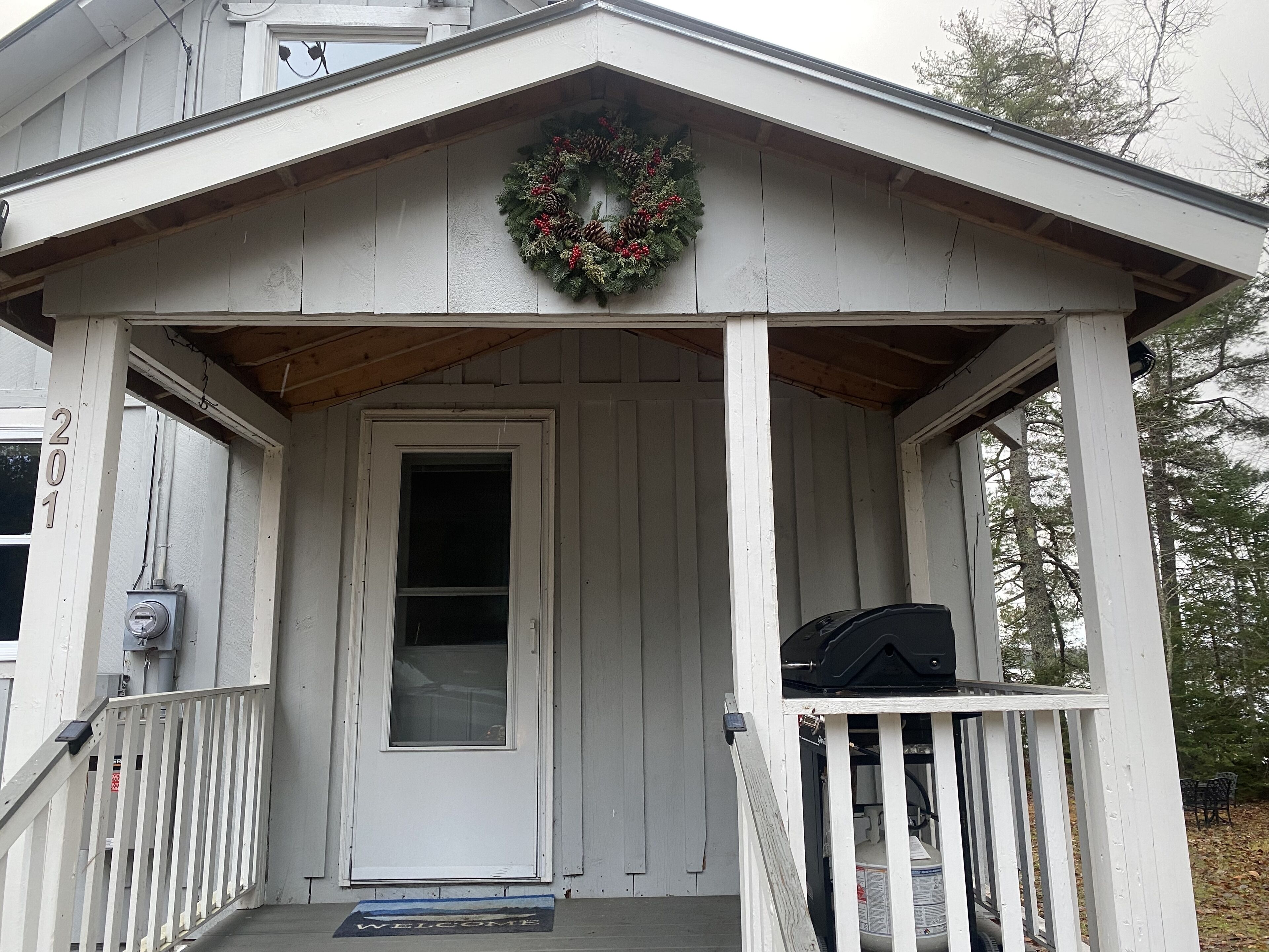 A house with a porch, a door, and a wreath.