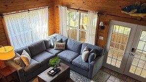 Una sala de estar acogedora con un sofá modular, una mesa de centro y un sillón a rayas.