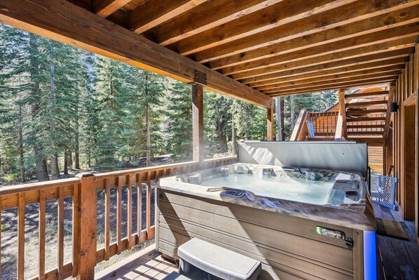 Relax in the hot tub on the outdoor deck overlooking the forest.