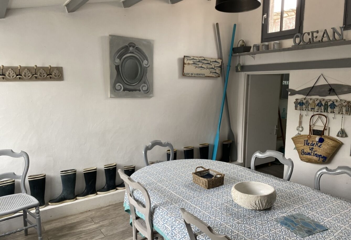 Uma área de refeições com uma mesa redonda, cadeiras, uma cesta e uma tigela.