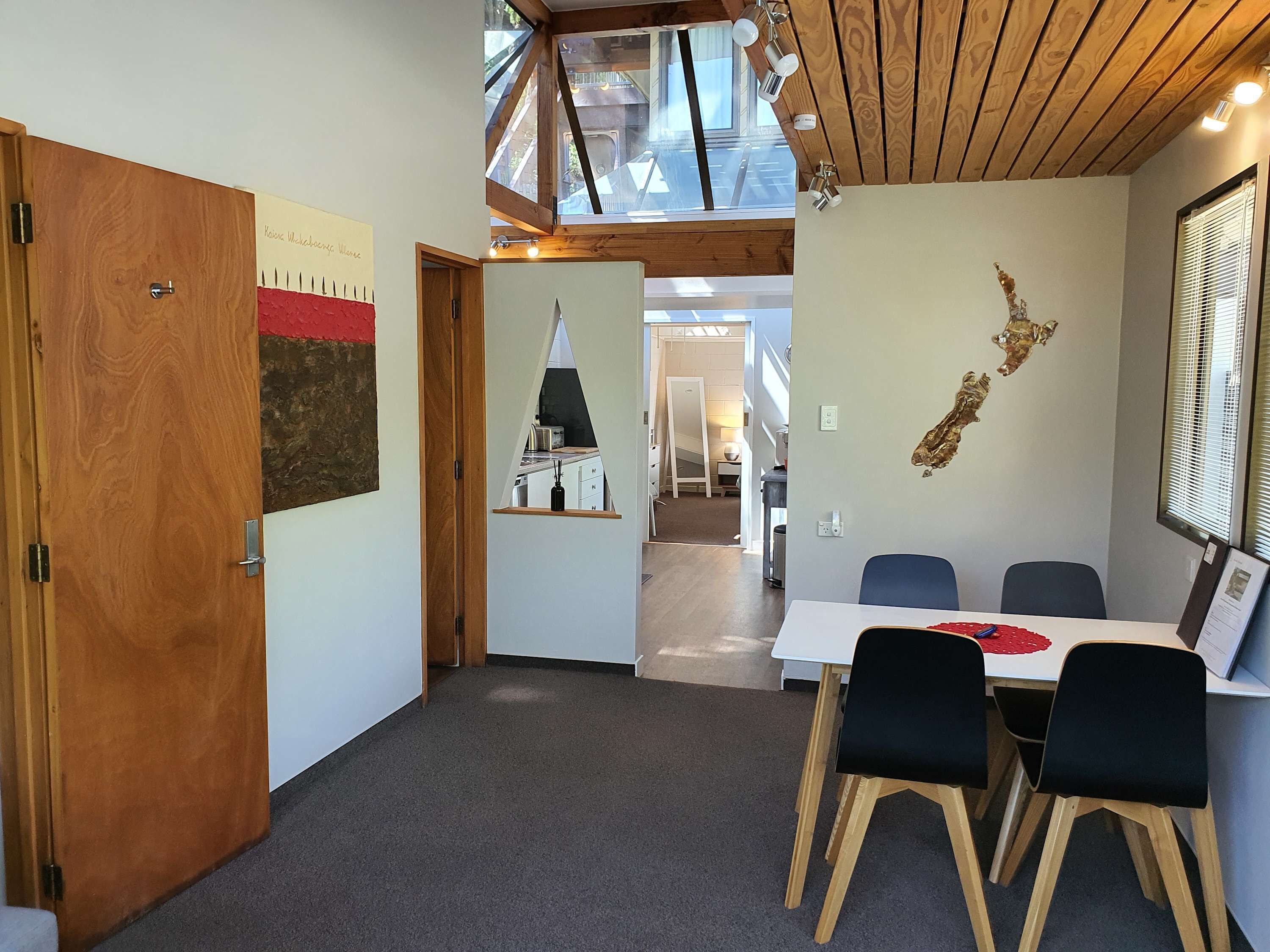 A conference room with a table and chairs, a wooden door, and a wall with a map and a framed picture.