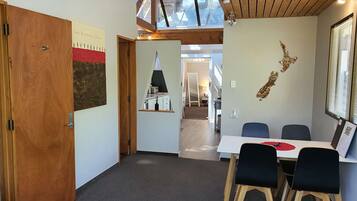 A conference room with a table and chairs, a wooden door, and a wall with a map and a framed picture.