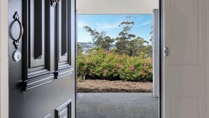 A doorway leading to a garden with a view of trees and a clear sky.
