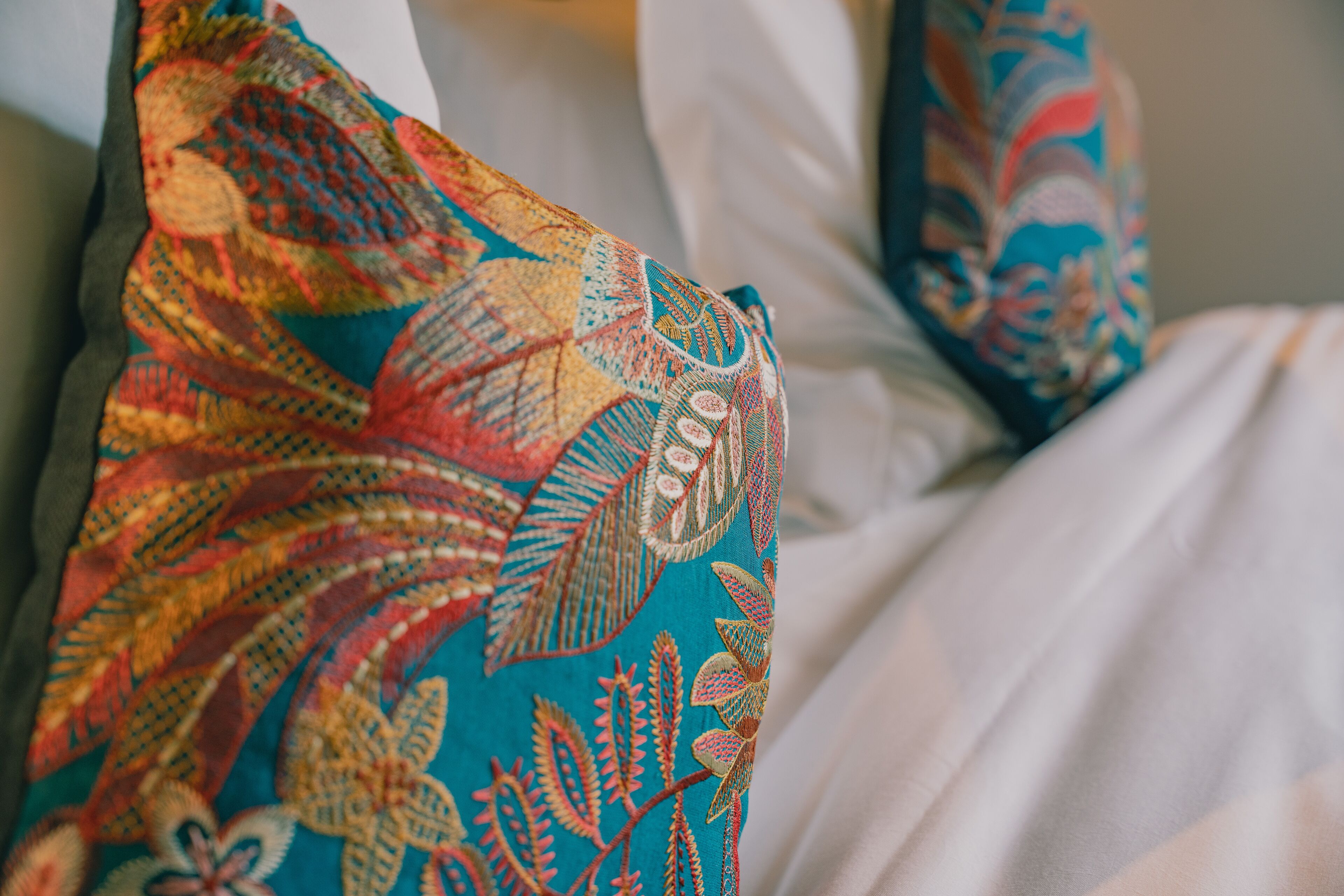 Un gros plan d’un lit recouvert d’une couverture colorée à motifs.