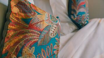 Un gros plan d’un lit recouvert d’une couverture colorée à motifs.