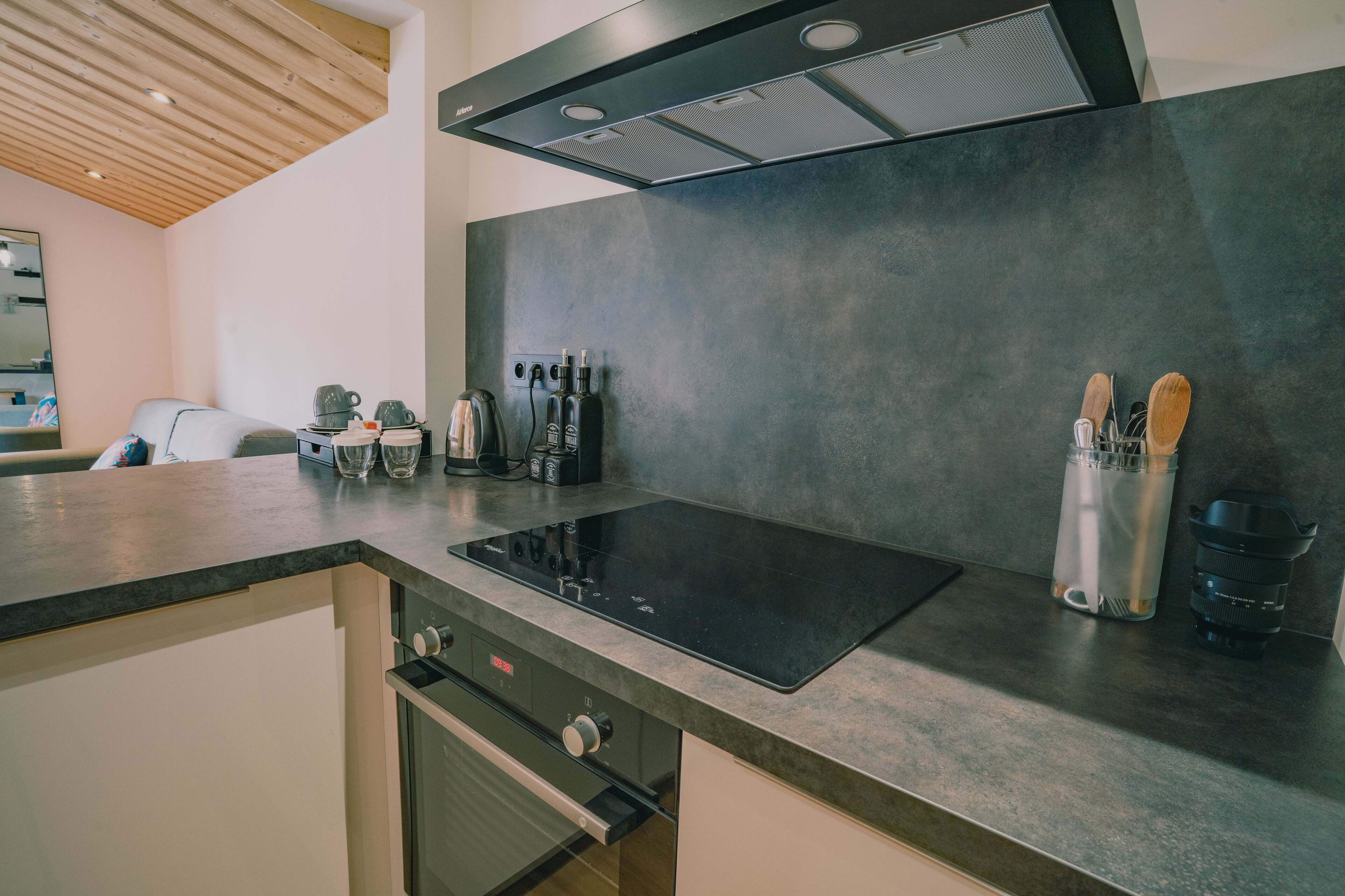 A modern kitchen with a black induction cooktop, stainless steel appliances, and a sleek countertop.