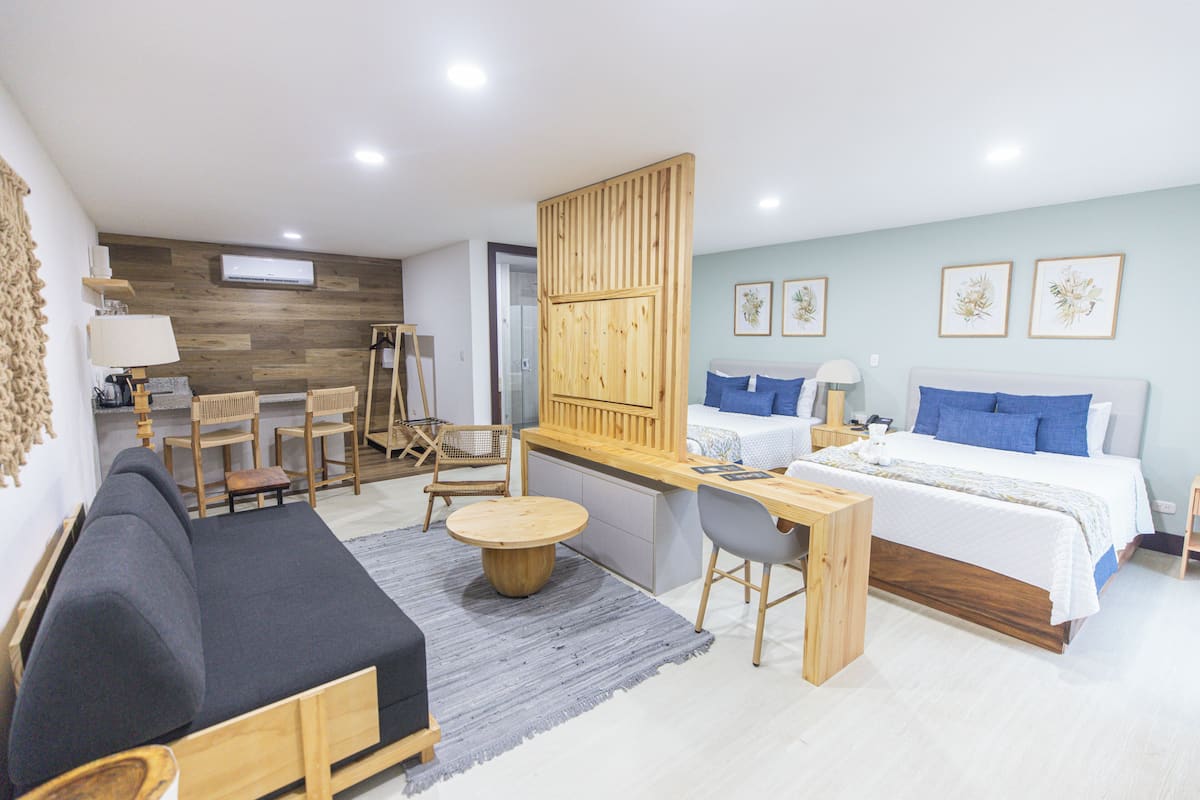 Une chambre d’hôtel moderne équipée d’un lit, d’un canapé, d’un bureau et d’une chaise.