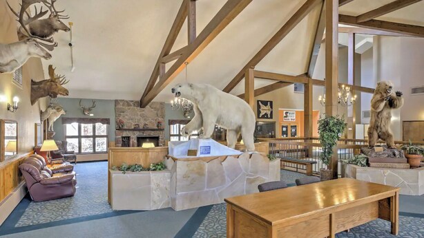 A spacious lobby with a stone fireplace, wooden beams, and various animal taxidermy. - Relax, Adventure, Views, Amenities +Memories (King) (Granby)
