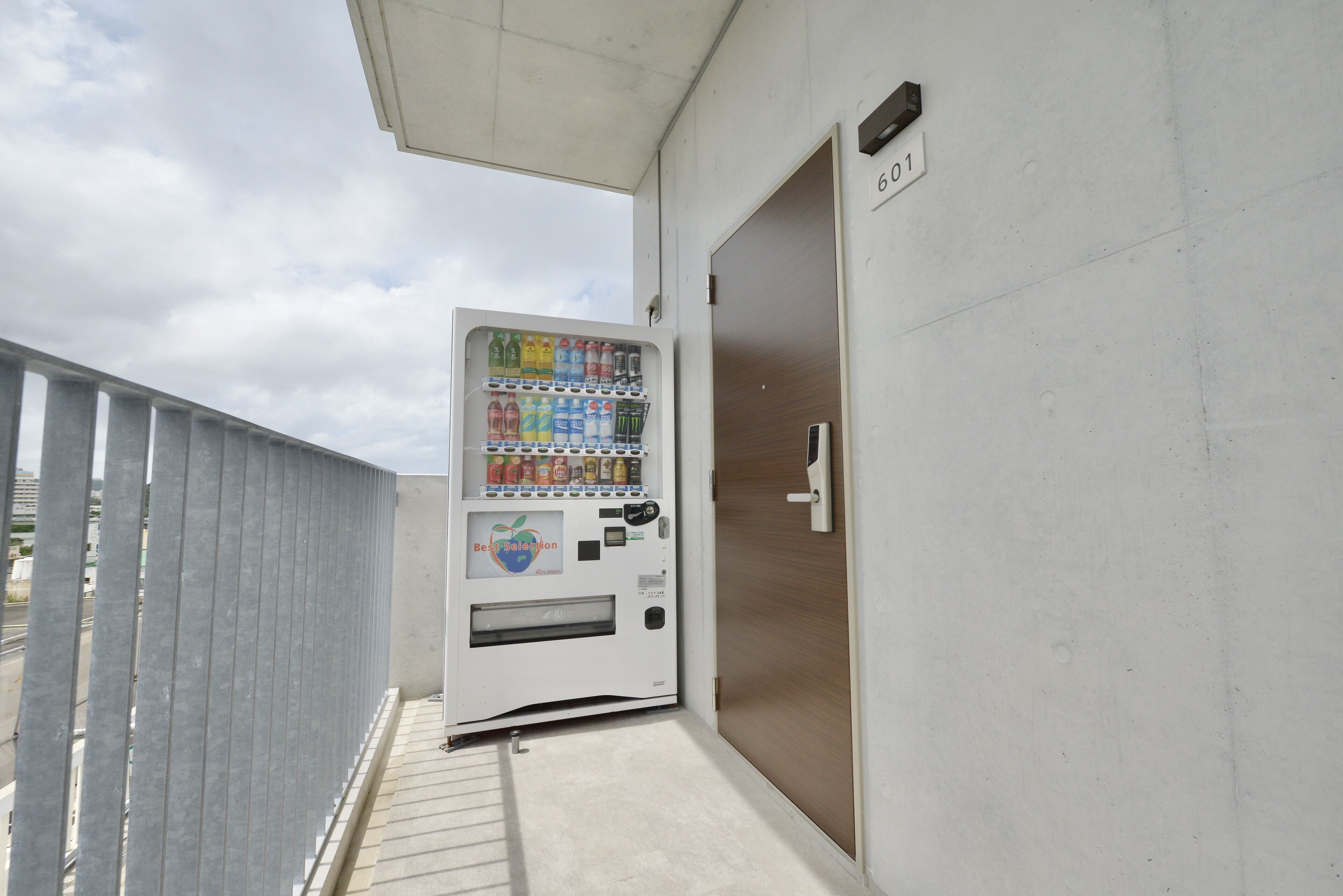 A vending machine with a variety of drinks and snacks, located next to a door with a number plate.