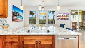 A kitchen with a large island, wooden cabinets, a Bosch dishwasher, and pendant lights.
