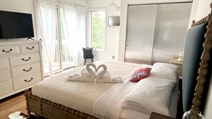 Une chambre à coucher comprenant un lit, une commode, un téléviseur et une armoire.