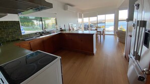 A modern kitchen with a large island, a stove, and a refrigerator.