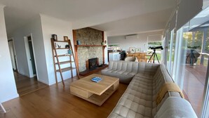 A modern living room with a large sectional sofa, a wooden coffee table, and a stone fireplace.