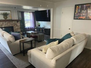 A living room with a sofa, coffee table, and a flat-screen TV.