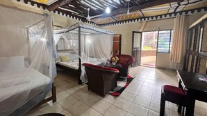 A room with a bed, a chair, a table, and a window. - Beautiful 3 Bedroom Villa in Diani Beach-sleeps 8 (Diani)