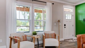 Een kamer met twee fauteuils, een tafeltje en een vloerlamp.