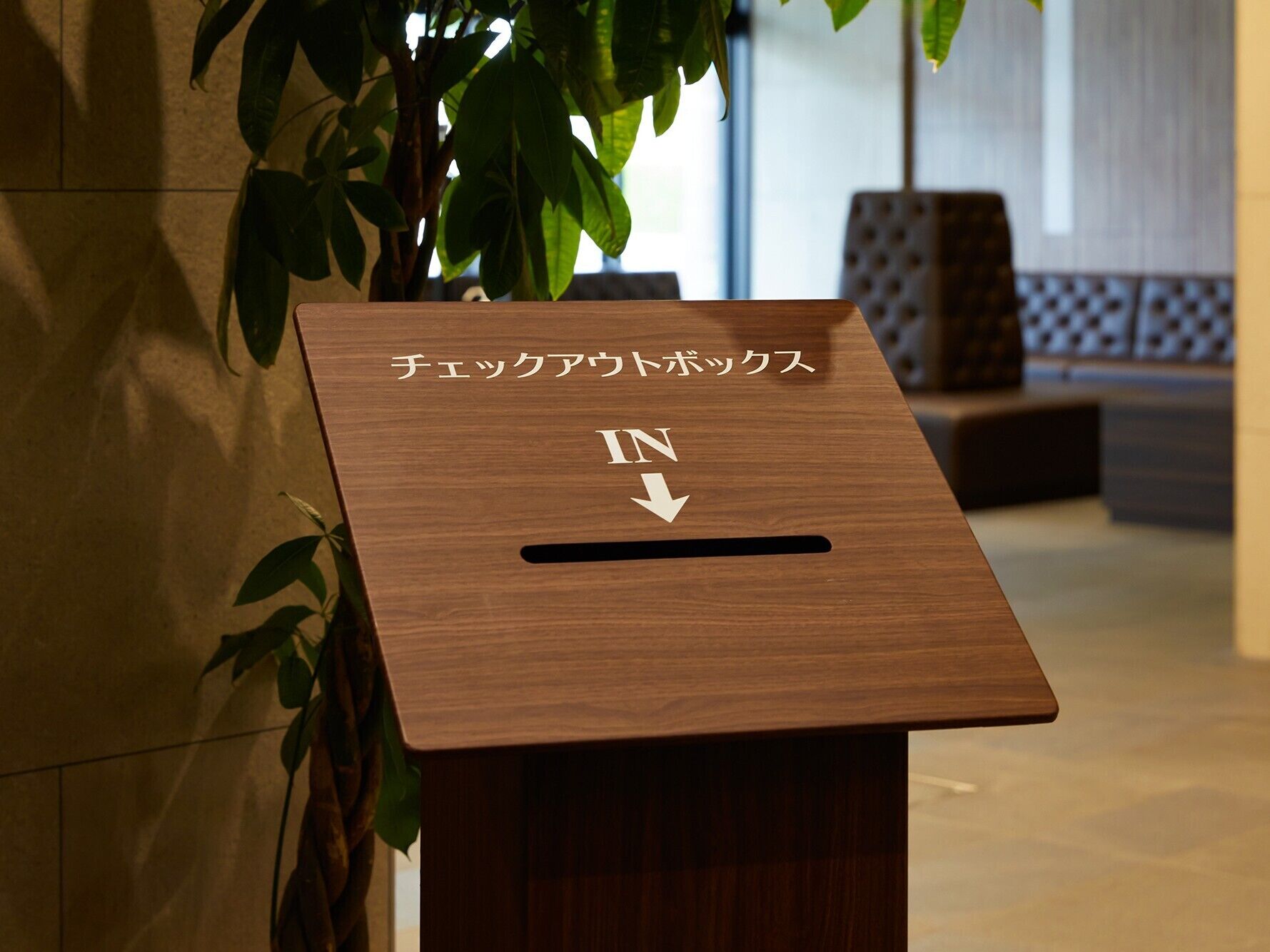 A wooden podium with Japanese text and an arrow pointing downwards.
