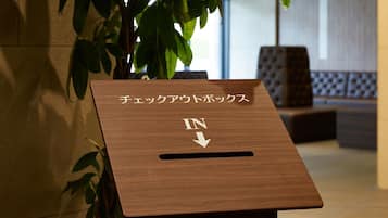 A wooden podium with Japanese text and an arrow pointing downwards.