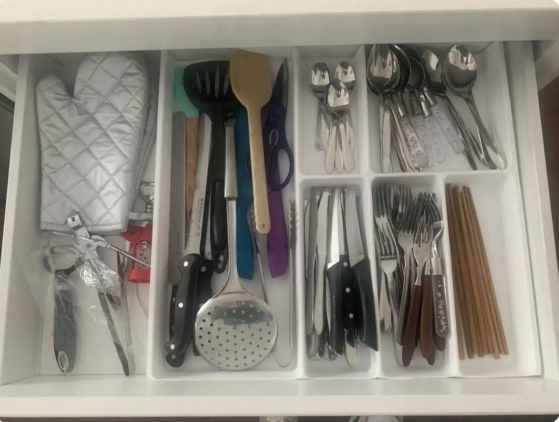 Un cajón con diversos utensilios de cocina organizados en compartimentos.