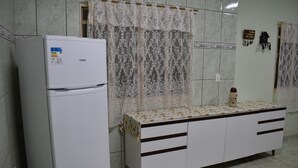A kitchen with a refrigerator, a patterned table, and a cabinet. - Canastra Ebenezer House in Vargem Bonita, MG (Vargem Bonita)