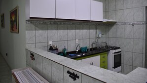A kitchen with a marble countertop, white cabinets, a stove, and a sink. - Canastra Ebenezer House in Vargem Bonita, MG (Vargem Bonita)