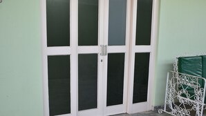 A set of double doors with frosted glass panels, a metal gate, and a tiled floor. - Canastra Ebenezer House in Vargem Bonita, MG (Vargem Bonita)