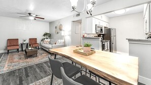 Una cocina moderna con una isla de madera, electrodomésticos de acero inoxidable y un ventilador de techo.