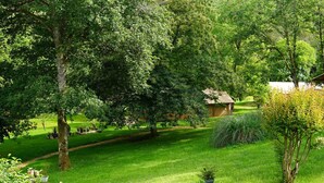 A lush garden with a variety of trees and a small building. - 1 Bedroom Chalet in Le Buisson de Cadouin (Le Buisson de Cadouin)