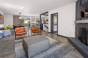 Relax in a comfortable seating area with a sofa and armchairs, enjoy a well-appointed kitchen, and warm up by the fireplace.