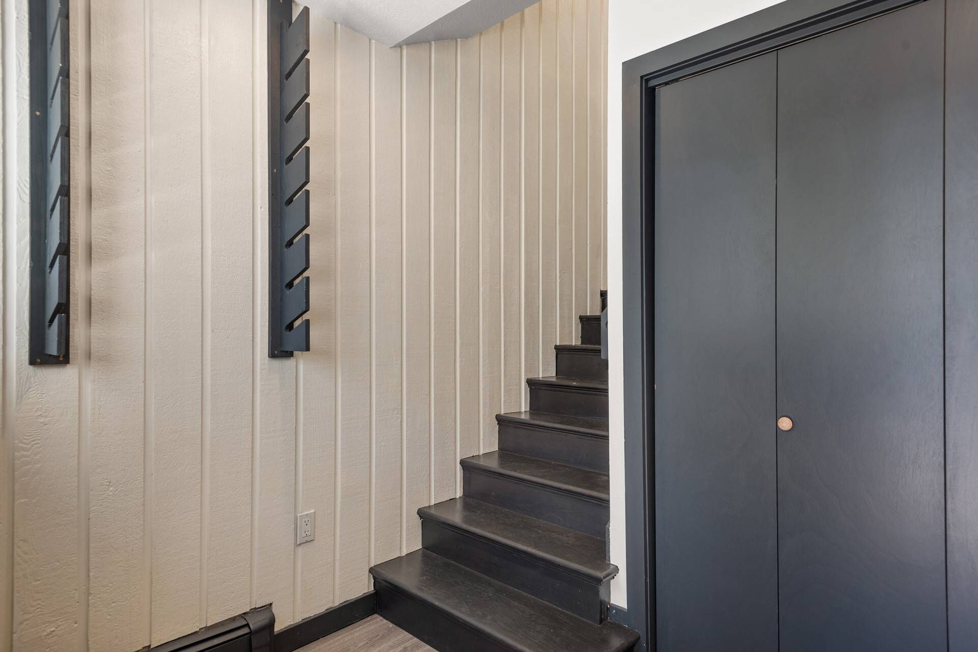 A staircase with dark steps leading to a closed door.