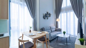 Un salon moderne comprenant un canapé, une table à manger avec des chaises et une petite table basse.