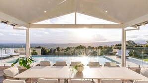 A modern outdoor pool area with a clear view of the landscape, a table with chairs, and a potted plant. - Miren Estate - lavish hinterland estate with pool (Federal)